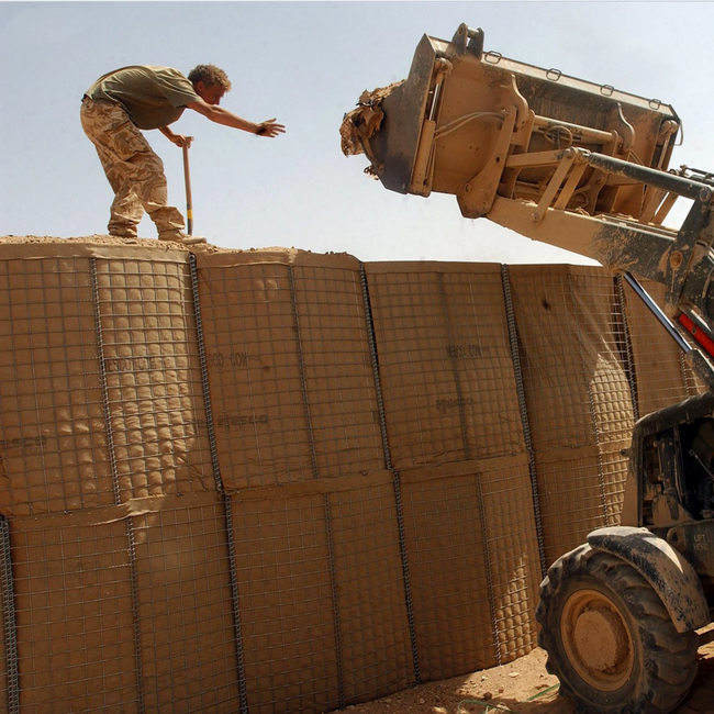Las barreras verdes y terrosas de la pared del bastión de Hesco soldaron con autógena la caja de Gabion
